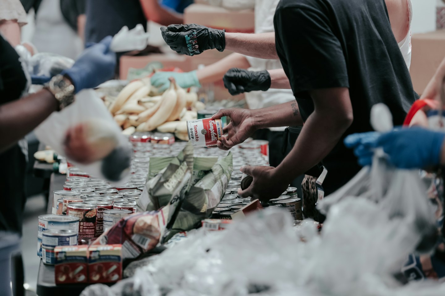 Volunteers sort canned goods and bananas at a food distribution event.