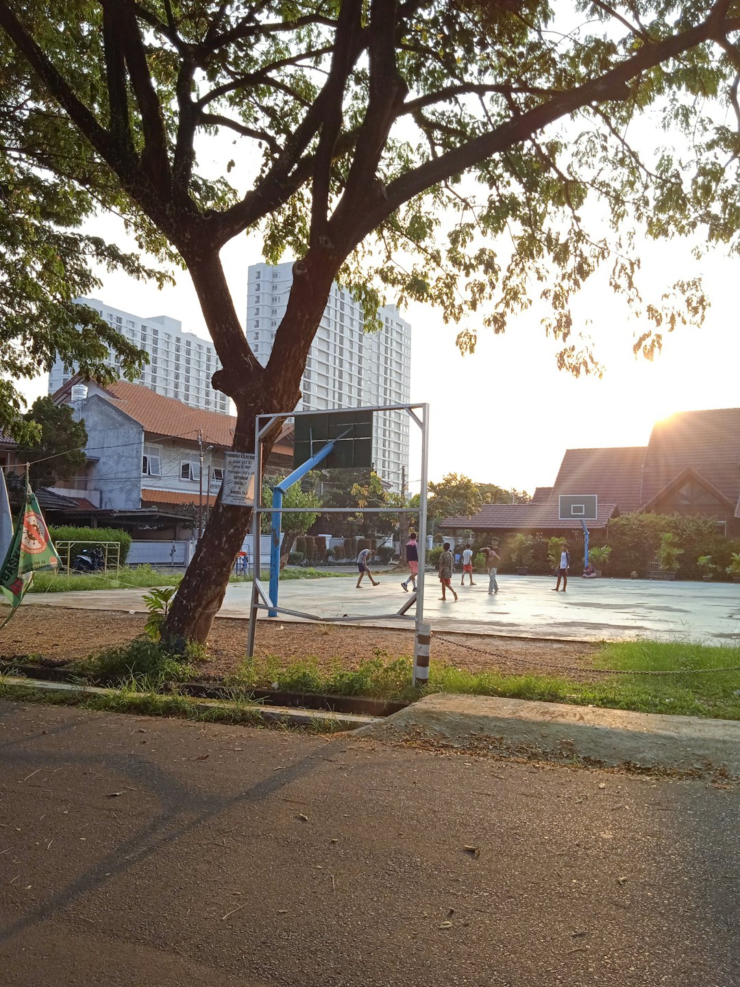 Children playing basketball on an outdoor court.
